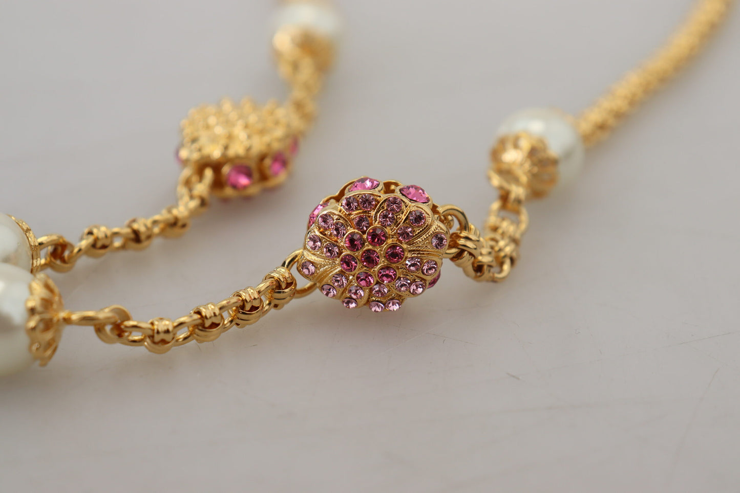 Goldfarbene Halskette mit floralen Kristallen und rosa Verzierung