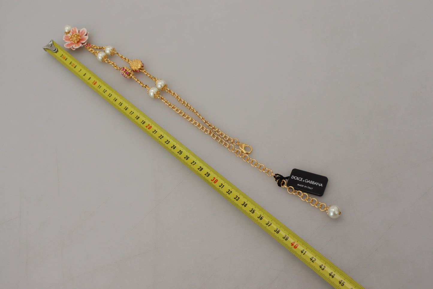 Goldfarbene Halskette mit floralen Kristallen und rosa Verzierung