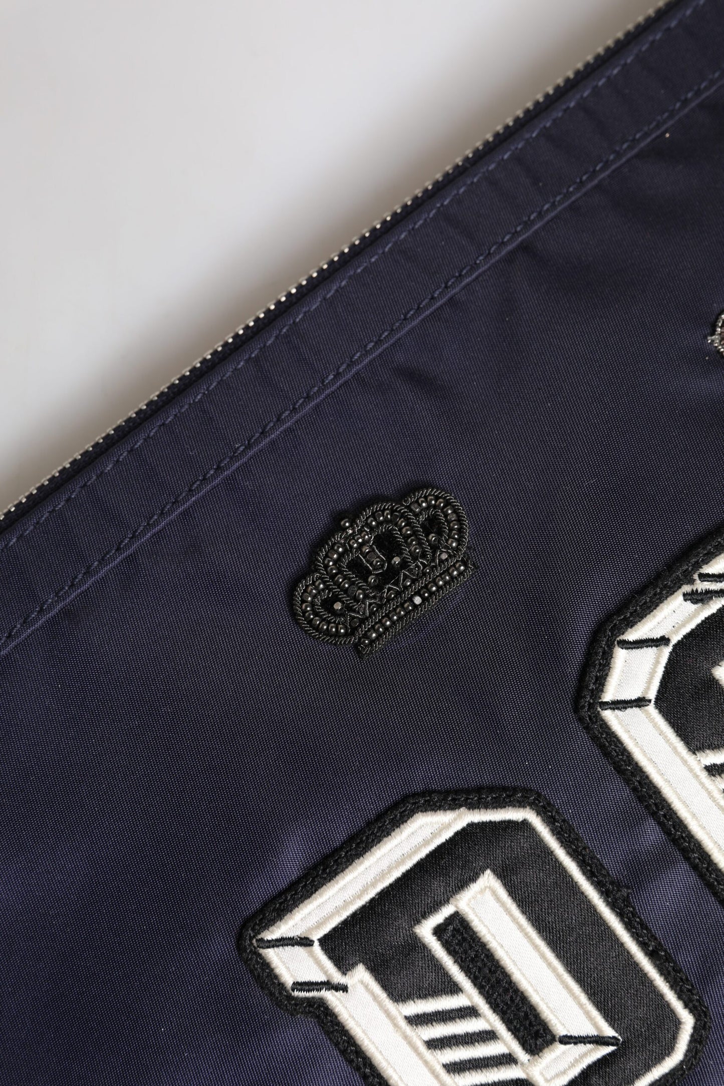 Blaue Clutch mit DG-Logo-Patch und Verzierung