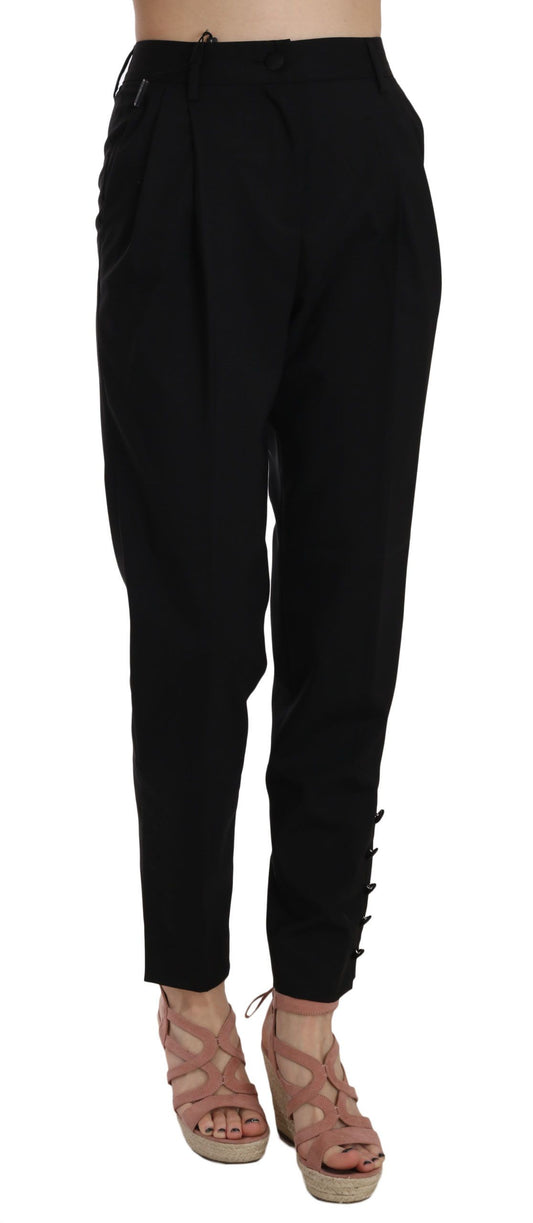 Schwarze, schmal zulaufende Hose mit Knopfleiste und Falten