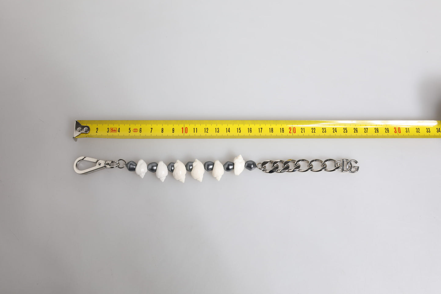 Silberfarbenes Armband mit Muschelanhänger und DG-Logo aus Messing